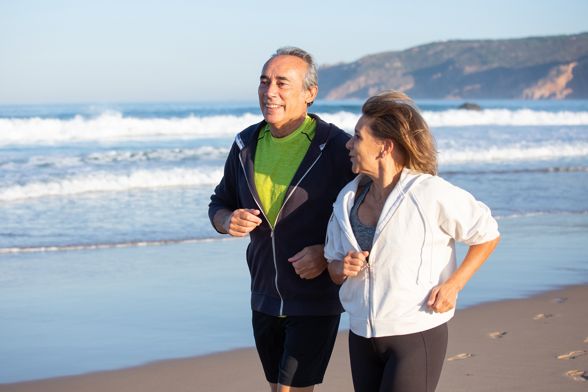 happy senior couple running along ocean coast summer day medium shot smiling caucasian man woman taking care health having cardio training family sport concept Traumatologo Ortopedista en Tijuana https://traumatologoentijuana.com
