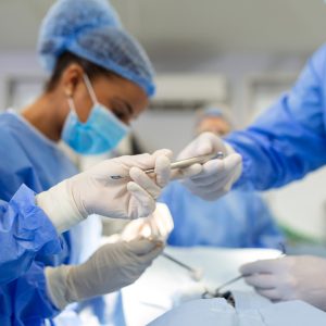 Shot in the Operating Room, Assistant Hands out Instruments to Surgeons During Operation. Surgeons Perform Operation. Professional Medical Doctors Performing Surgery.